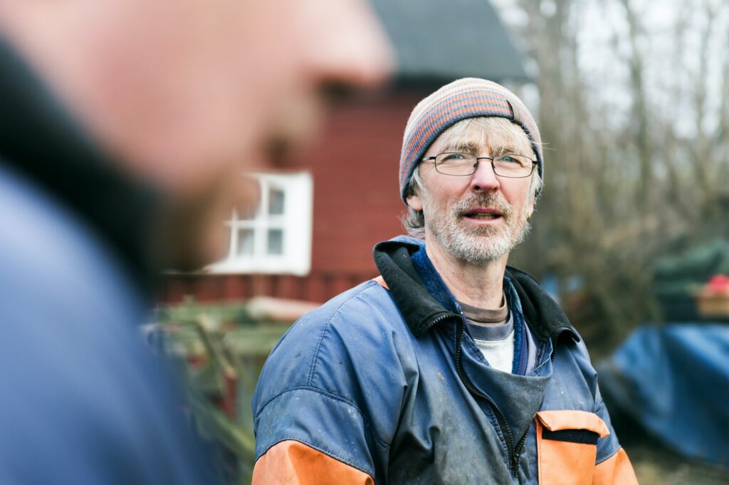 Mature fisherman with colleague in foreground