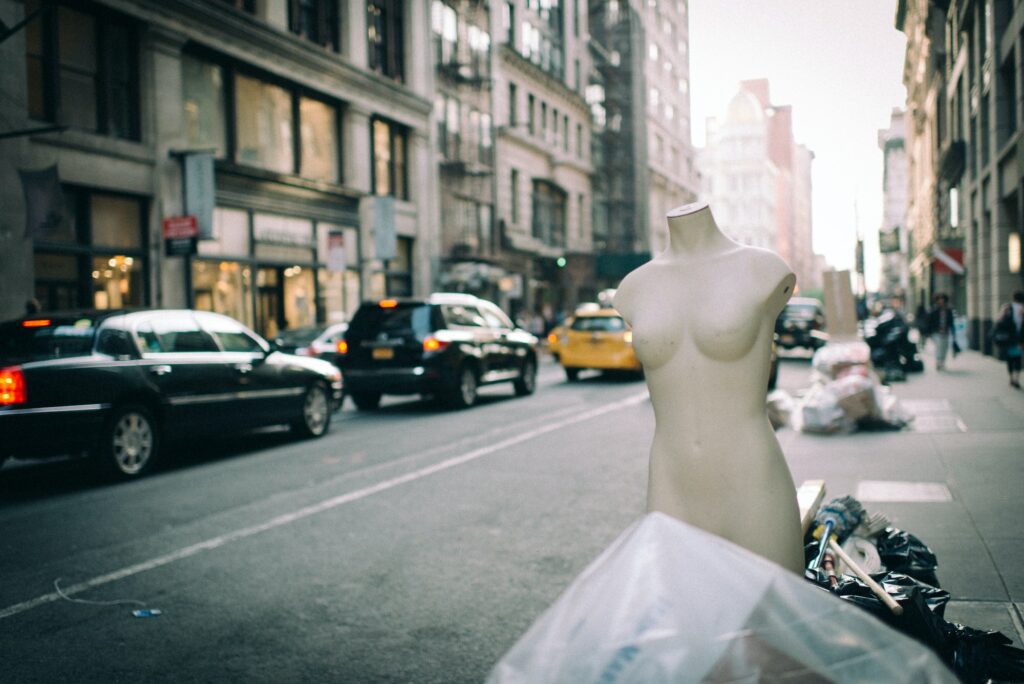 Naked mannequin out with the street trash in front of city street