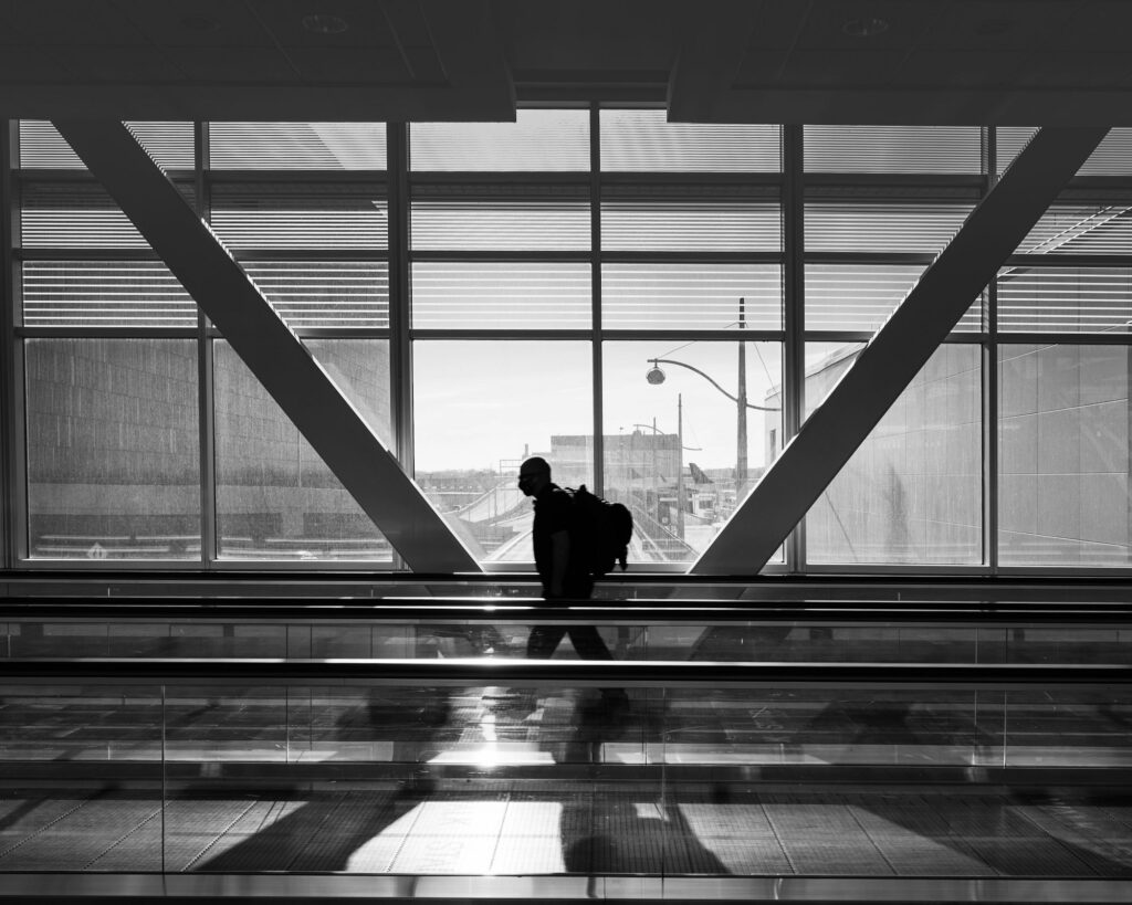 Monochrome shot of a person on the escalator in the airport